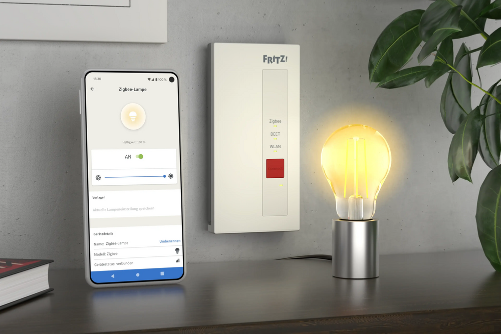 Smart Home Steuerung: Smartphone zeigt Zigbee Lampe neben smarter Glühbirne auf einem Tisch.
