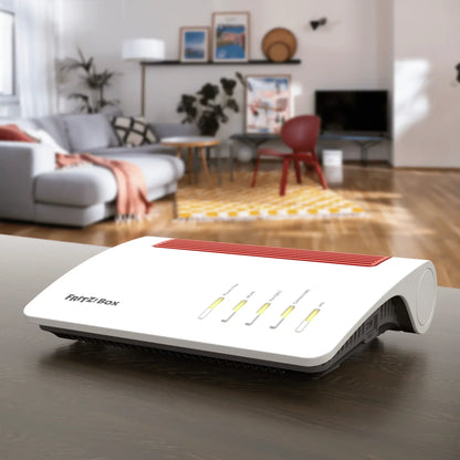 FRITZ!Box 5590 Fiber Router auf einem Tisch in modernem Wohnzimmer mit grauem Hintergrund.